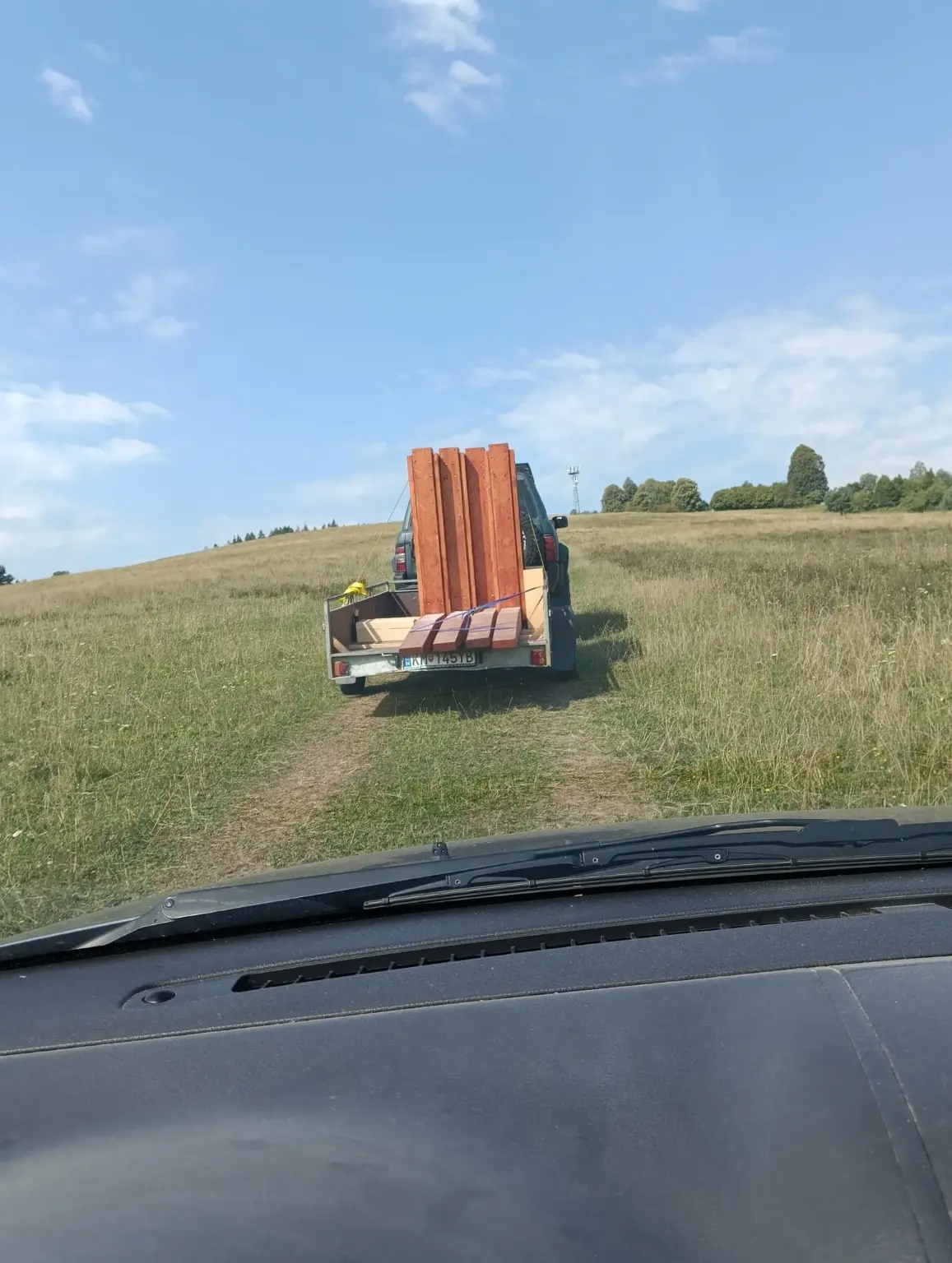 Prevoz častí lavičky po lúke na miesto stavby